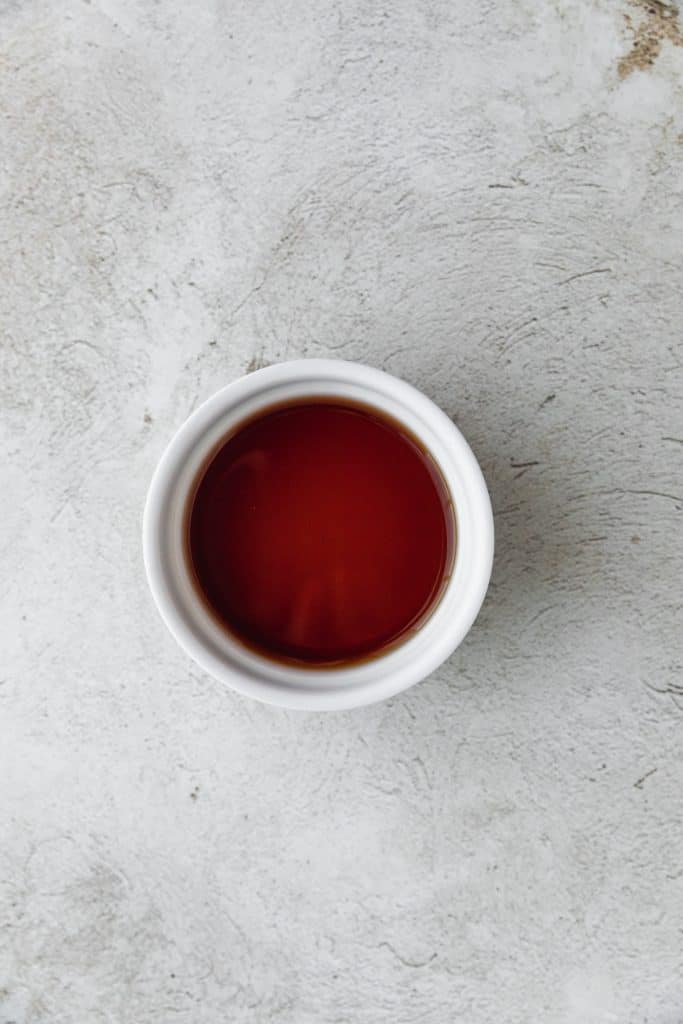 a ramekin filled with sherry vinegar on a light surface