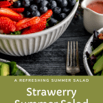 Strawberry summer salad with strawberries, blueberries, avocado, candied nuts, feta and strawberry dressing