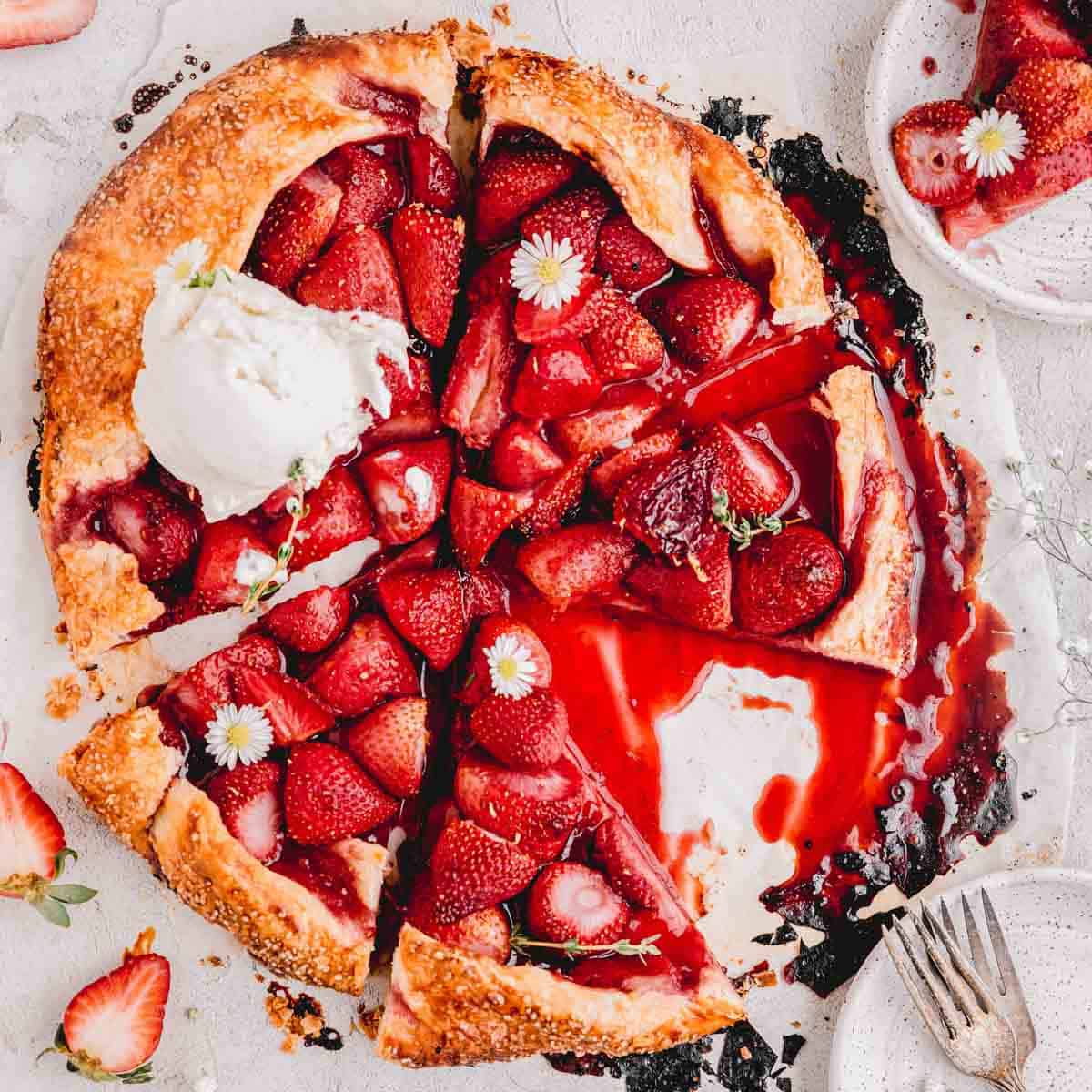 Strawberry Galette cut into triangles with a scoop of vanilla ice cream on top.