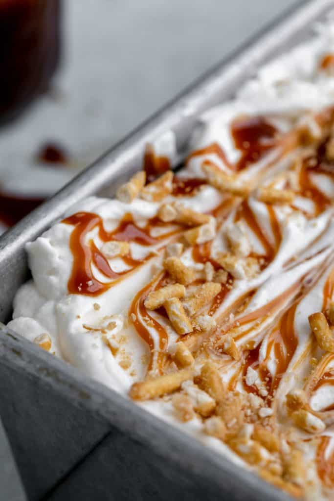 close up of layered ice cream with caramel and pretzels