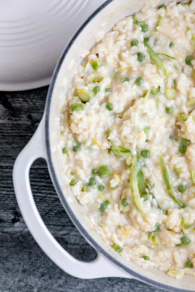 cooked risotto in a pot with peas and asparagus
