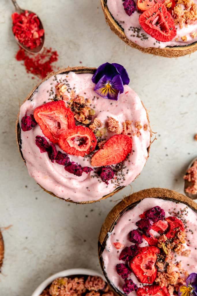 strawberry banana smoothie bowls served in coconuts