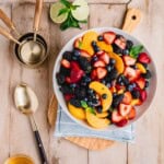 Honey Lime Fruit Salad with summer fruits and a lime honey ginger dressing in a bowl.