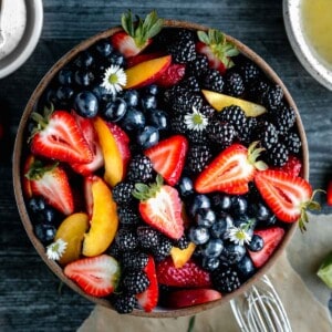 Summer Fruit Salad in a bowl with strawberries, peaches, blueberries, blackberries and mint.