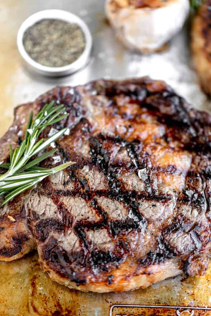 close up of grilled ribeye steaks with rosemary and flaky sea salt