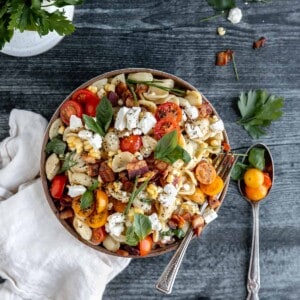Summer Pasta Salad with tomatoes, corn, bacon, herbs and feta cheese in a bowl.