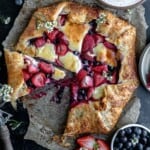 Berry Cheesecake Galette with a couple slices taken out and berries to the side.