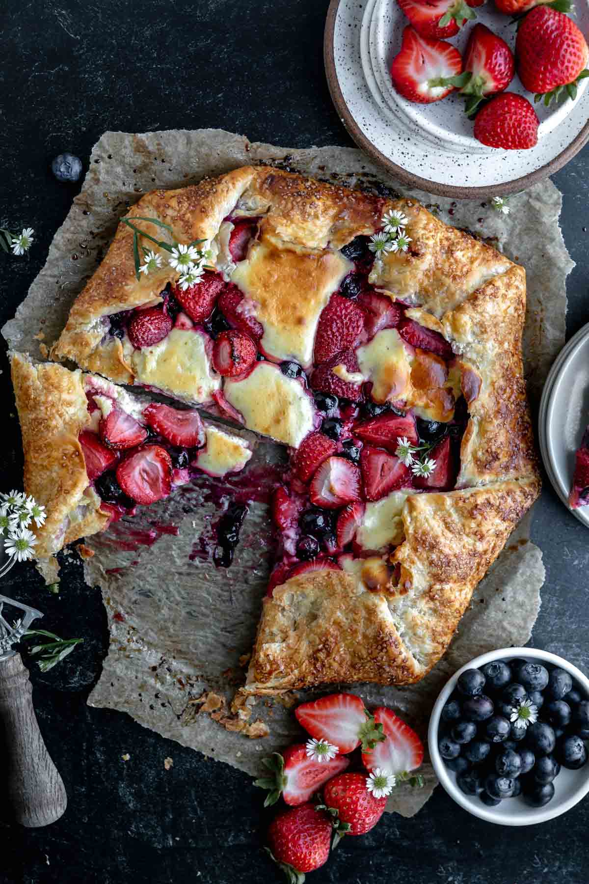 Berry Cheesecake Galette with a couple slices taken out and berries to the side. 