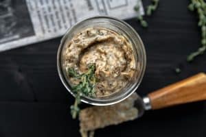 burnt onion aioli in a small glass jar with a spreader next to it