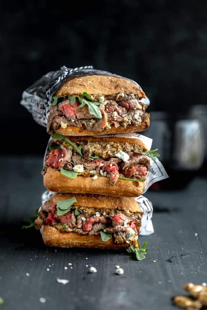 marinated flank steak sandwiches stacked on top of each other