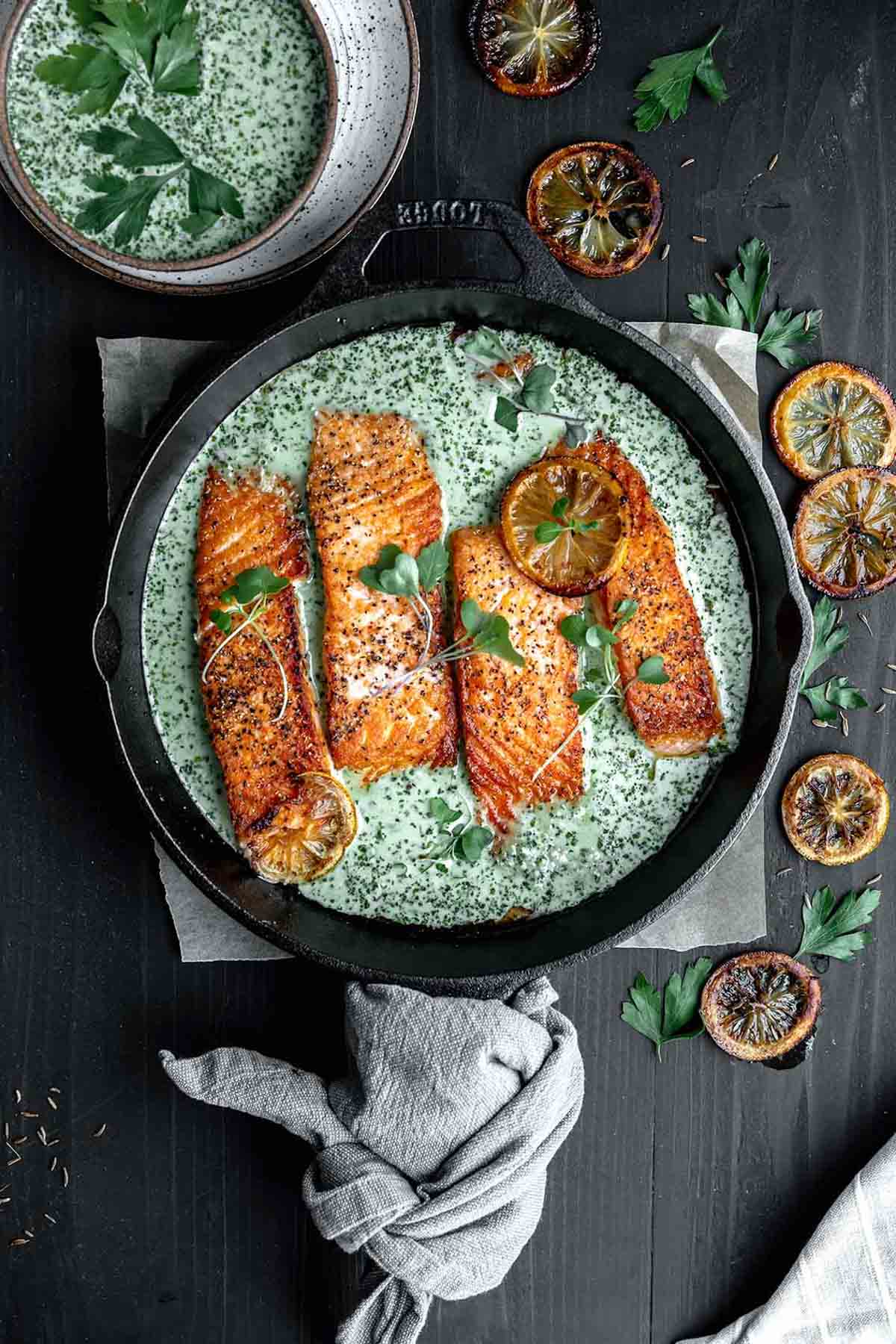 Cast Iron Salmon topped with creamy schug sauce and cilantro. 
