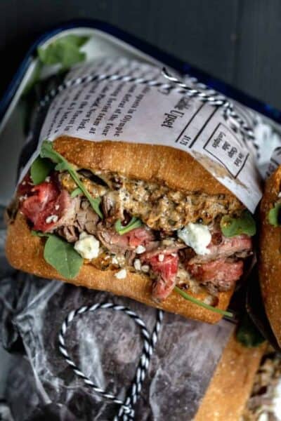 marinated flank steak sandwich on ciabatta with arugula and blue cheese wrapped in deli paper