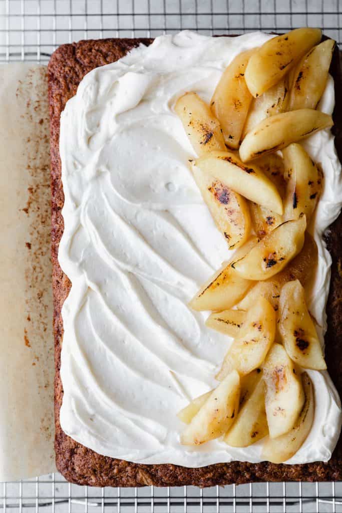apple cake topped with frosting and bruleed apples