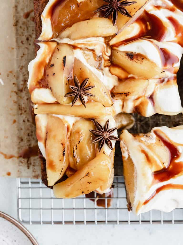 caramel apple snack cake topped with bruleed apples, frosting and caramel sauce