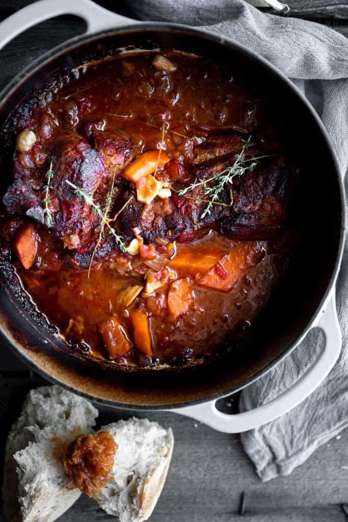 pork, tomato, wine, onion, carrots braising in a pot