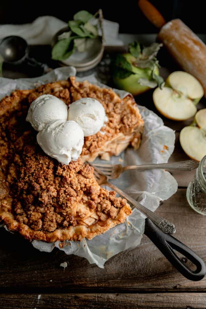 ice cream piled on top of the Dutch apple pie with once slice cut out
