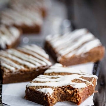chewy molasses blondies with white chocolate drizzled over the top with a bite taken out of one of them