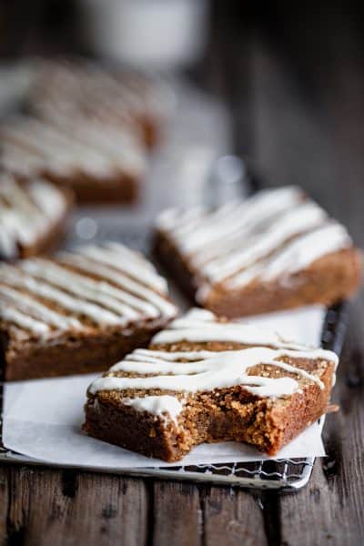 chewy molasses blondies with white chocolate drizzled over the top with a bite taken out of one of them