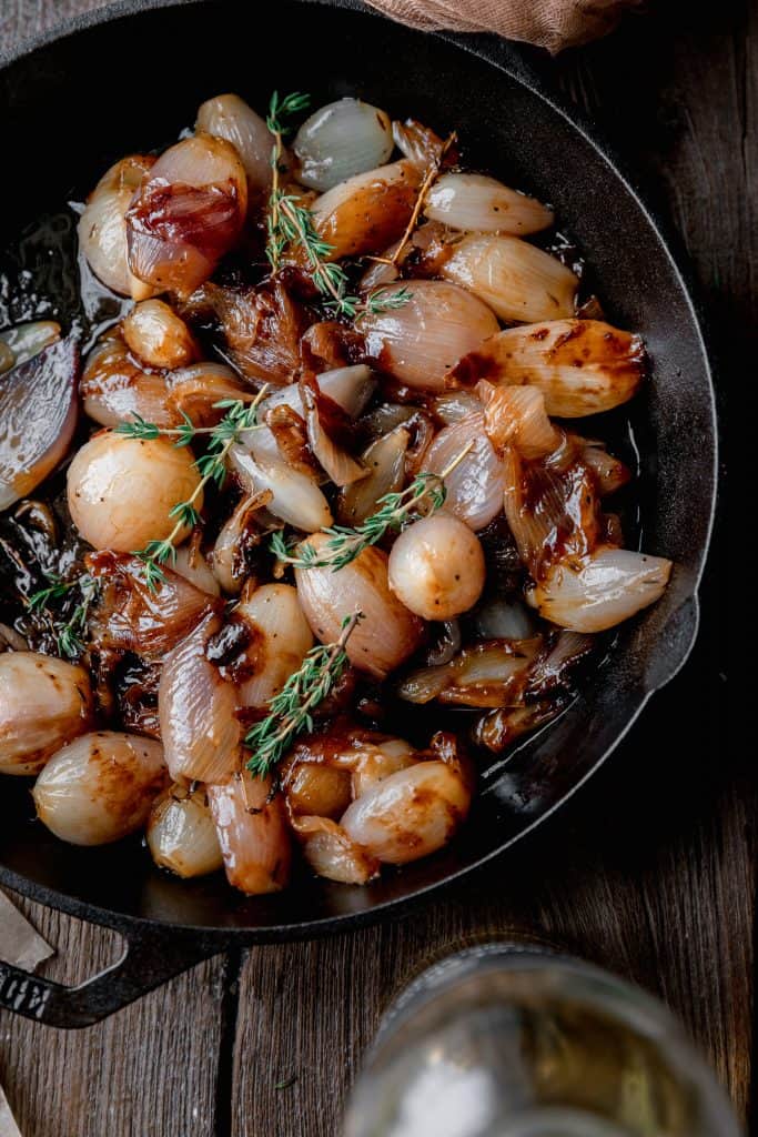 glazed shallots in a cast iron skillet