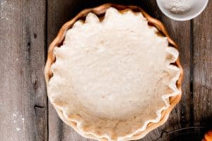 pie dough in the pan with crimped edges
