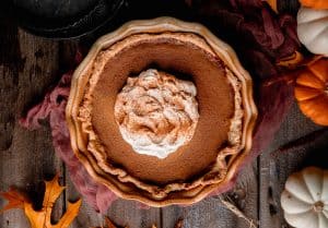 perfectly spiced pumpkin pie topped with whipped cream and cinnamon
