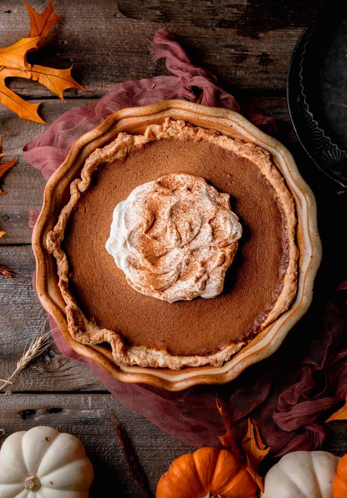 perfectly spiced pumpkin pie topped with whipped cream and cinnamon