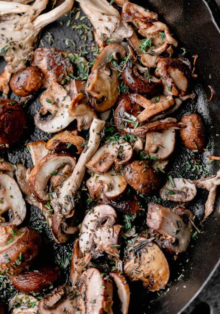 mushrooms sautéed in a pan with herbs and garlic