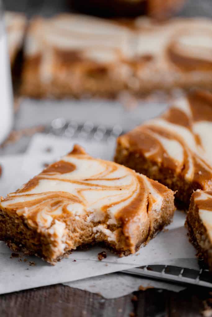 pumpkin swirl cheesecake bar with a bite taken out of one piece