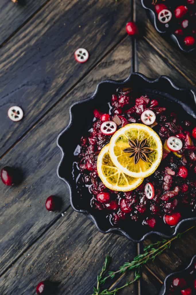 cranberry orange sauce in a dish topped with orange slices and star anise