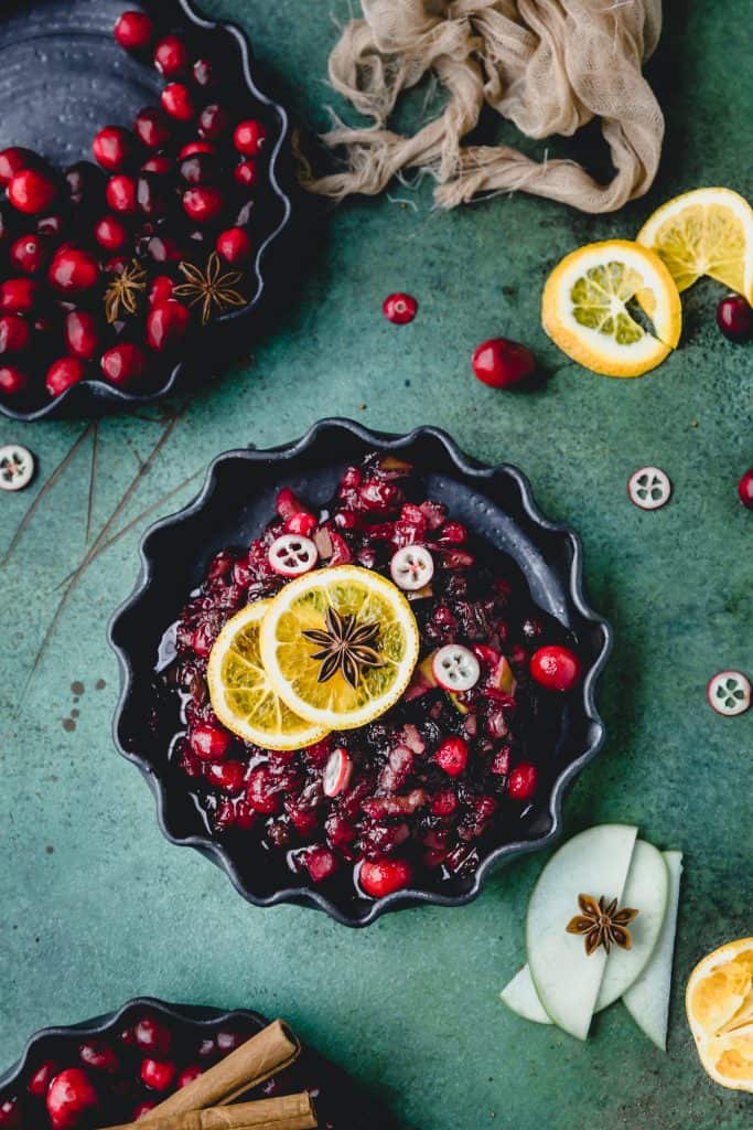 cranberries in a pie plate with apple slices next to it