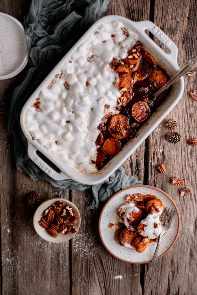 over the top shot after the potatoes have been baked and topped with marshmallows. One side plate with a serving on it