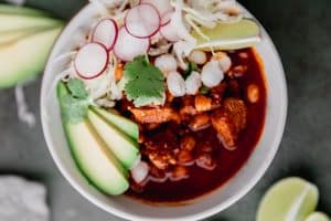 a bowl of pozole rojo with all the toppings