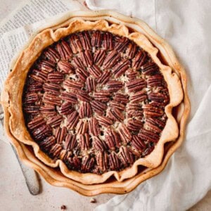 Southern Pecan Pie in a pie dish with a top layer of pecans and golden brown crust.