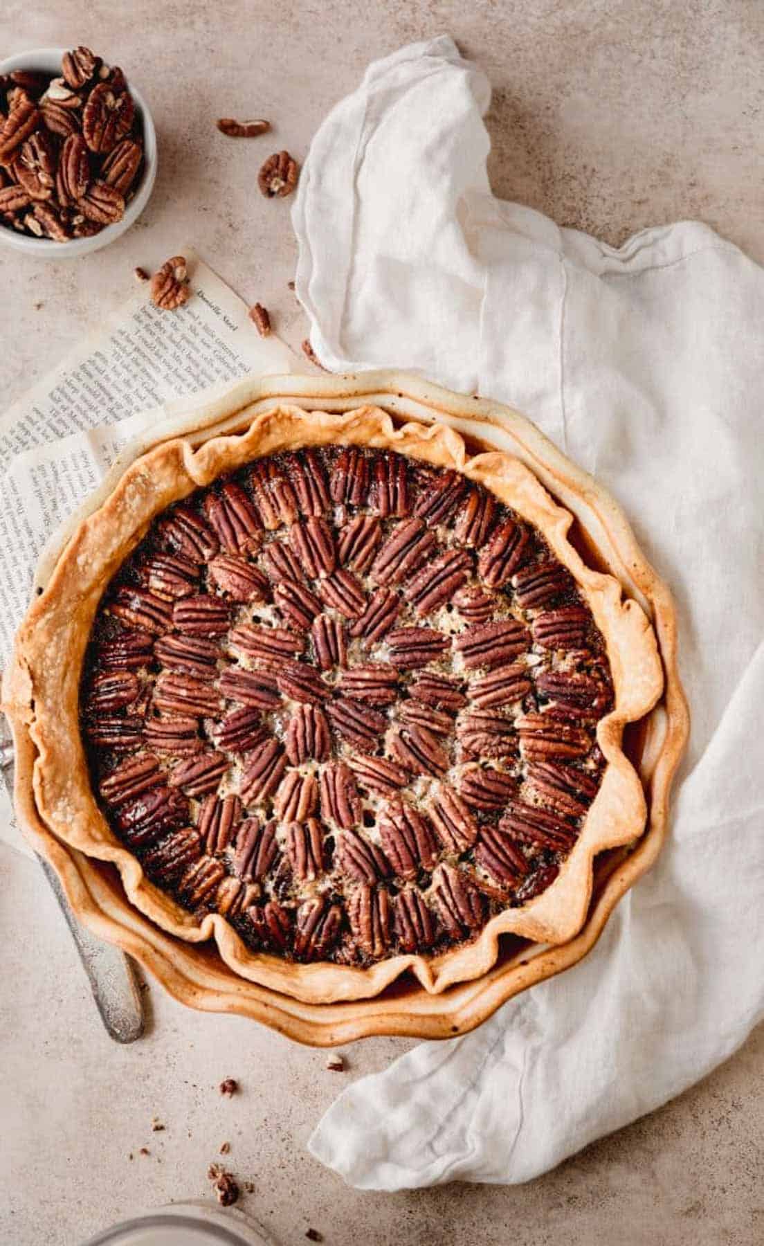 Southern Pecan Pie in a pie dish with a top layer of pecans and golden brown crust. 