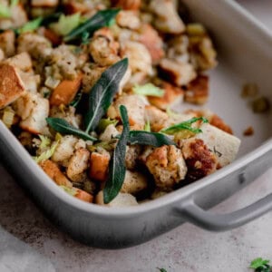 Traditional Bread Stuffing topped with sage in a baking dish.