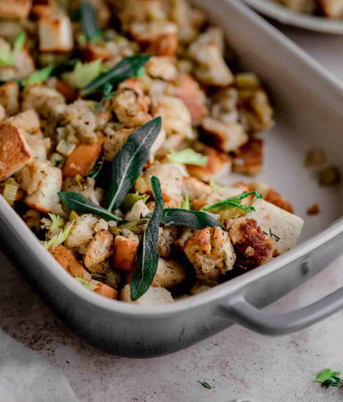 Traditional Bread Stuffing topped with sage in a baking dish. 