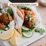 falafel pita with sauce, toppings and lemon wedges