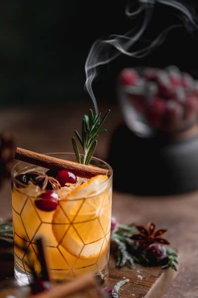bourbon apple cider cocktail with smoking rosemary garnish