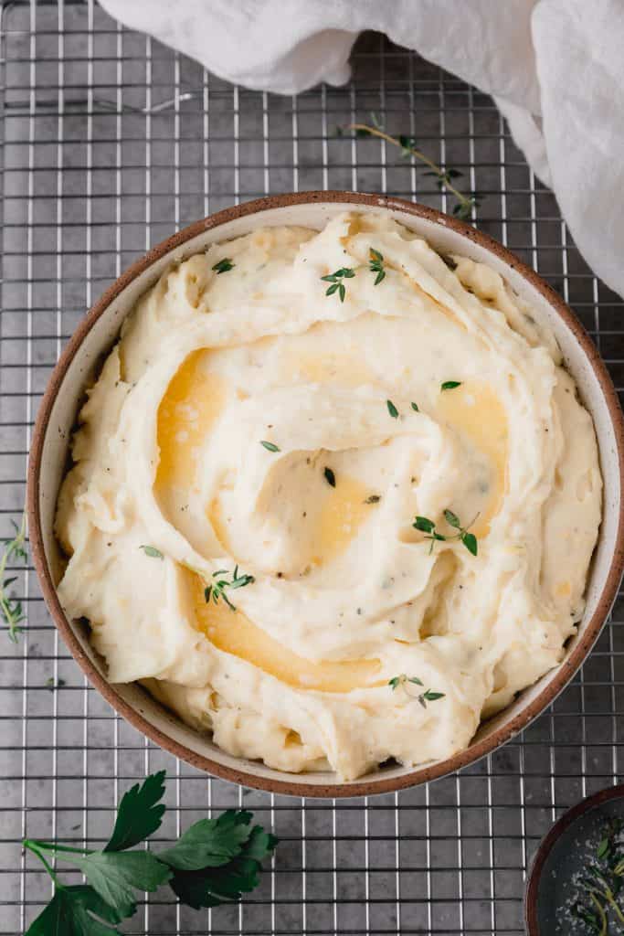Boursin mashed potatoes in a bowl with butter and herbs