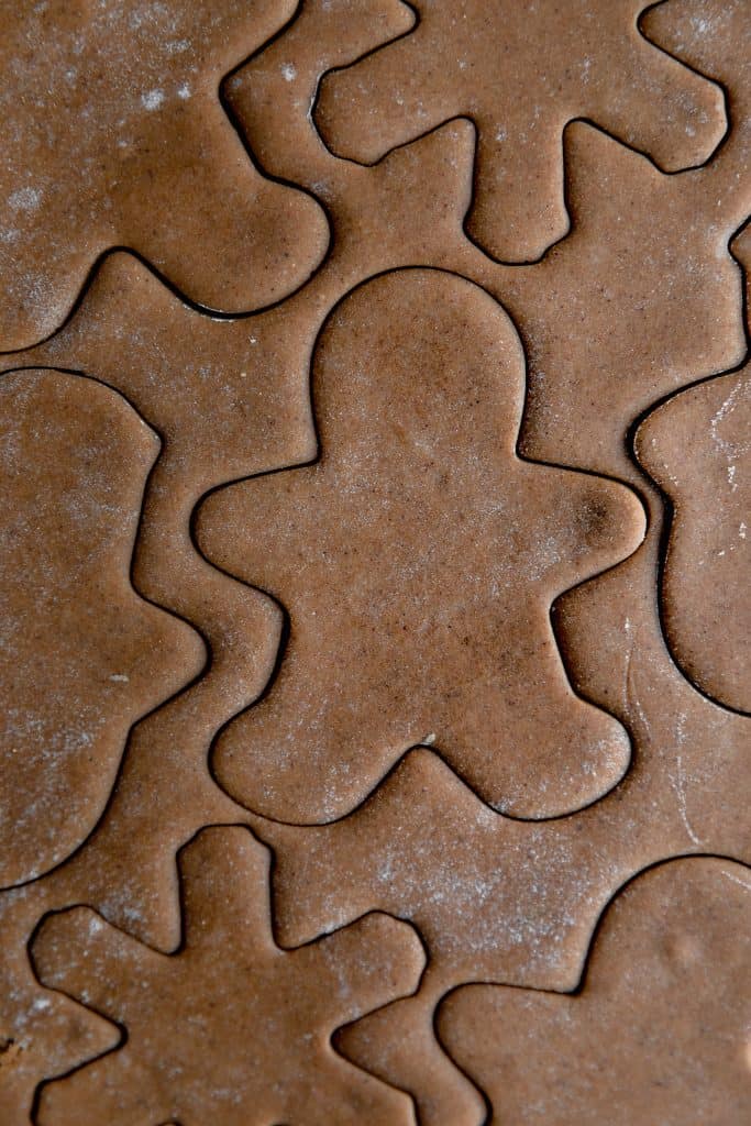 cut outs of a gingerbread man and snowflake in the cookie dough