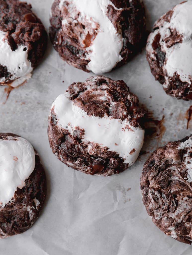 hot chocolate cookies spread on parchment paper after being baked