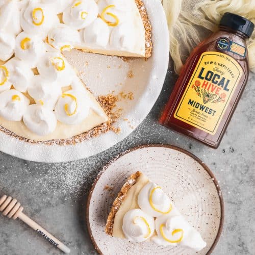 honey lemon chiffon pie with a bottle of local hive honey next to it and a pie slice on the plate