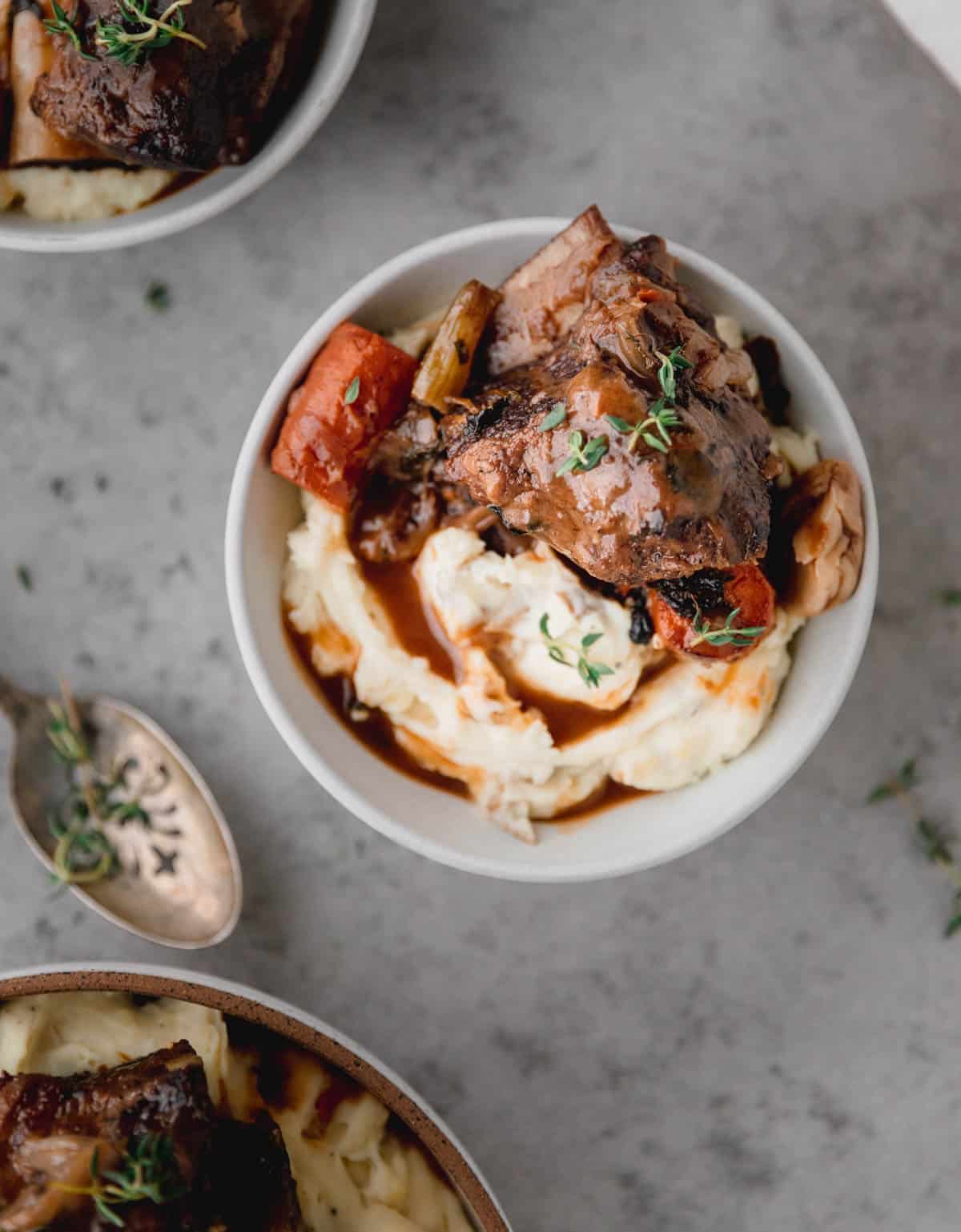 Red Wine Braised Short Ribs over mashed potatoes with gravy in a bowl. 