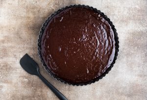 chocolate ganache filling poured into the cooled Oreo crust