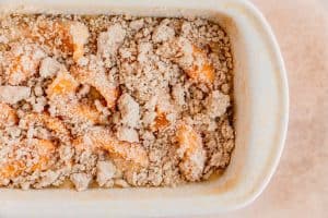 pound cake topped with peaches and cobbler topping before being baked