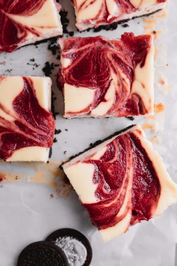 Strawberry cheesecake bars sliced on parchment paper
