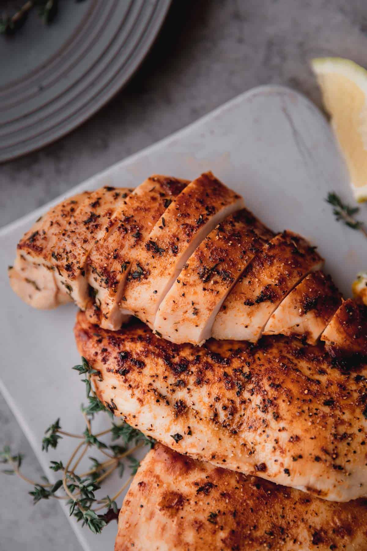 Juicy Air Fryer Chicken Breast sliced on a plate.