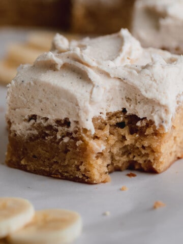 Banana Bars with brown butter frosting that has a bite taken out.