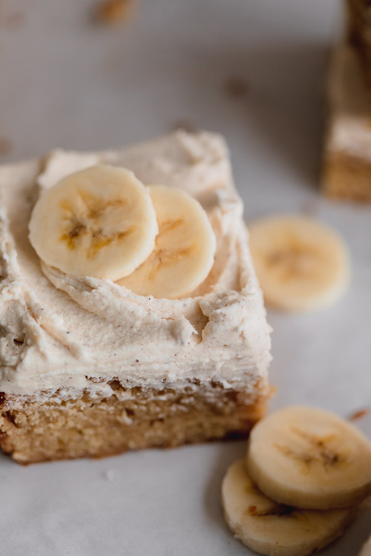 Banana Bars with brown butter frosting topped with fresh banana slices. 