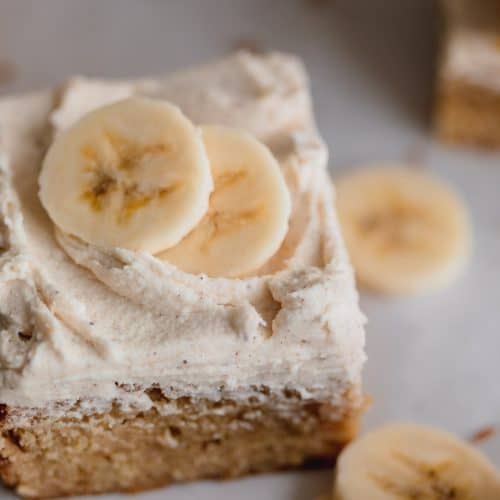banana bars with brown butter frosting and sliced bananas on top